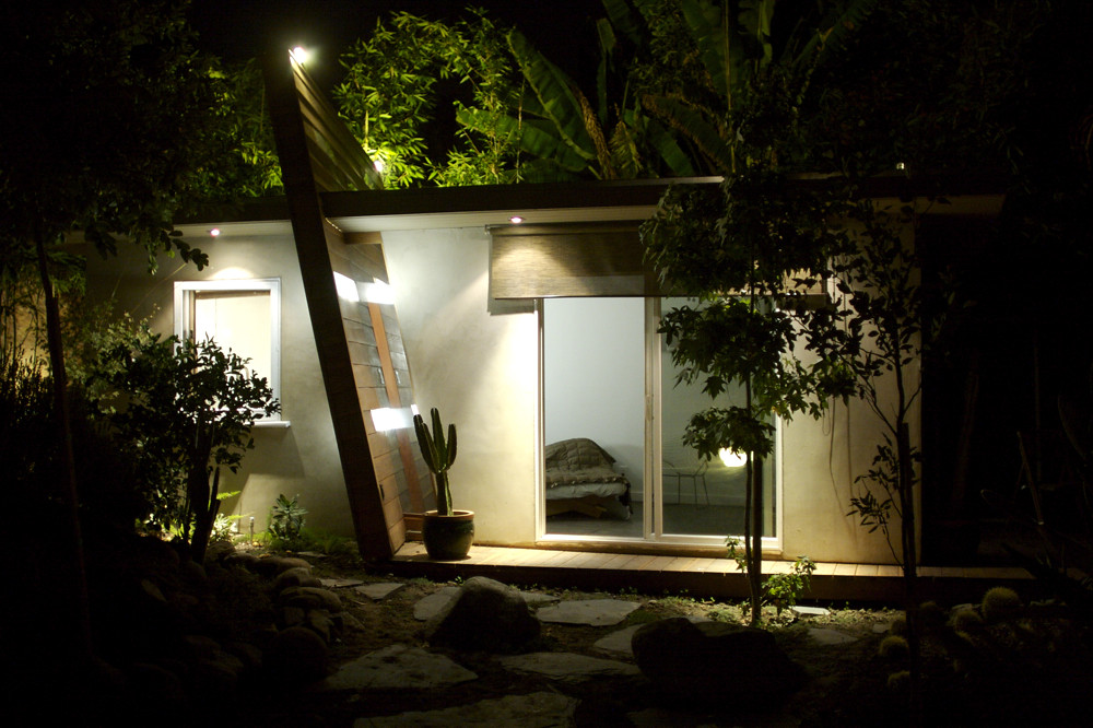 Home exterior illuminated at night by professional permanent lighting